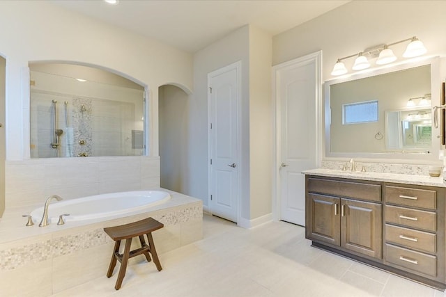 bathroom with a garden tub, a tile shower, a closet, and vanity