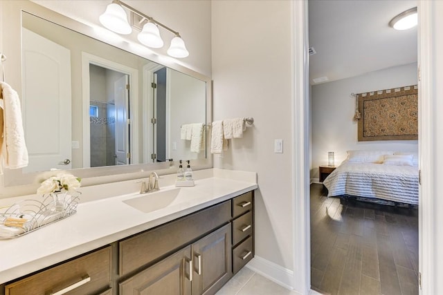 full bath with wood finished floors, vanity, baseboards, a shower stall, and ensuite bath