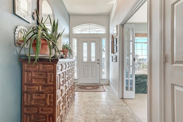 foyer featuring a textured wall and light tile patterned flooring