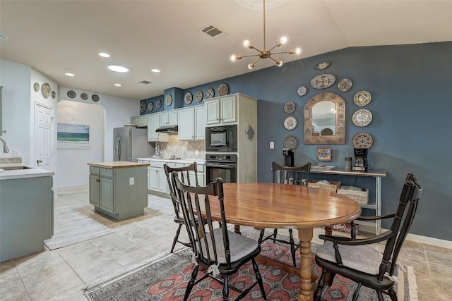 dining room featuring lofted ceiling, visible vents, a notable chandelier, and baseboards