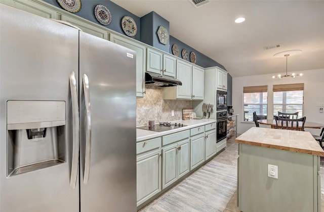 kitchen featuring a center island, backsplash, butcher block countertops, under cabinet range hood, and black appliances