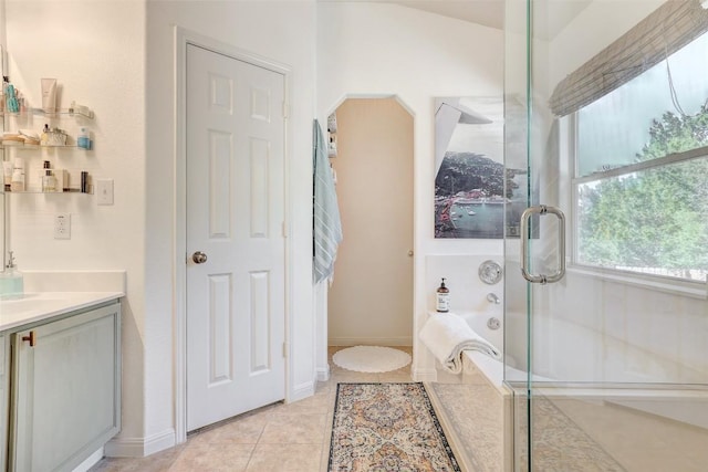 bathroom with tile patterned flooring, vanity, baseboards, a shower stall, and a bath