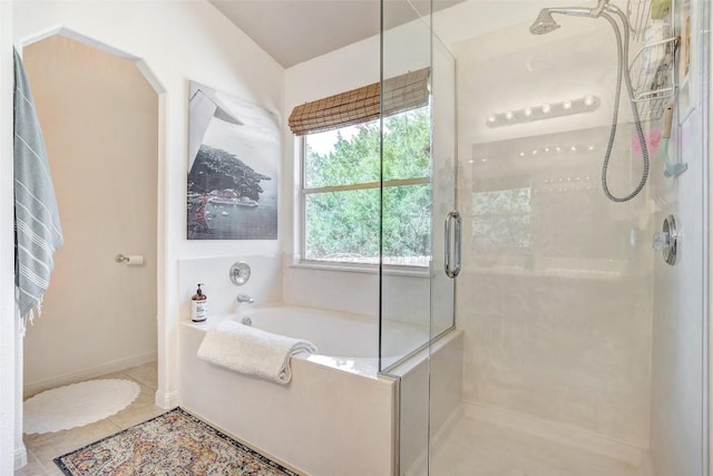 full bathroom featuring a stall shower, a bath, and tile patterned floors