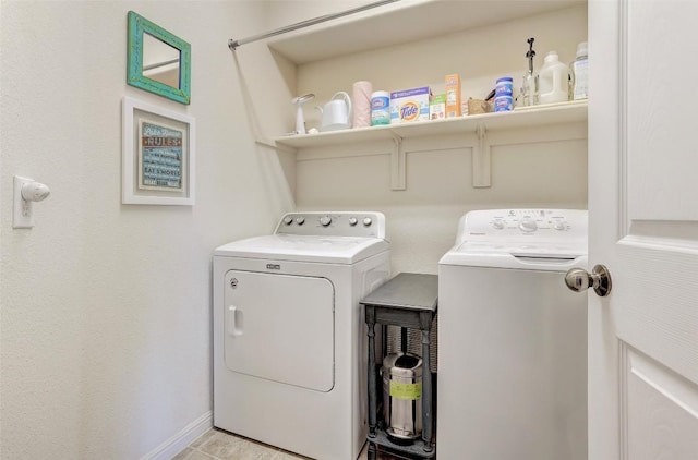 washroom featuring laundry area, washing machine and clothes dryer, and baseboards