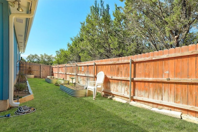 view of yard featuring a garden and a fenced backyard