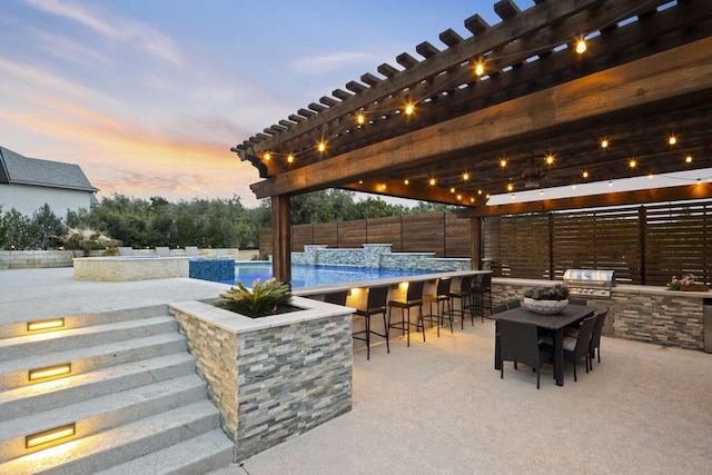 patio terrace at dusk with exterior bar, area for grilling, fence, grilling area, and a pergola