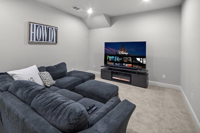 living room with a glass covered fireplace, carpet flooring, visible vents, and baseboards