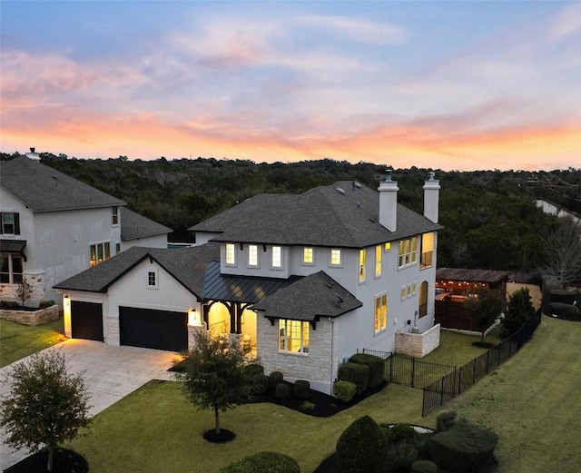 view of front of house featuring a chimney, fence, a garage, driveway, and a front lawn