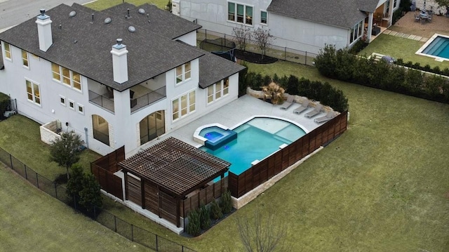 view of swimming pool featuring a patio area, a fenced backyard, a pool with connected hot tub, and a yard