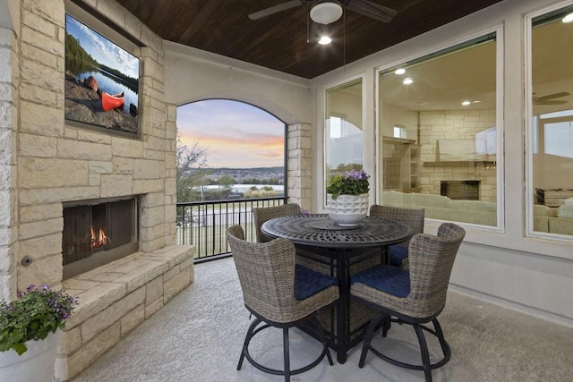 interior space featuring ceiling fan and an outdoor stone fireplace