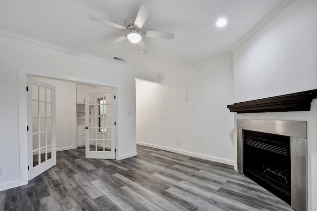 unfurnished living room with ceiling fan, wood finished floors, visible vents, baseboards, and crown molding