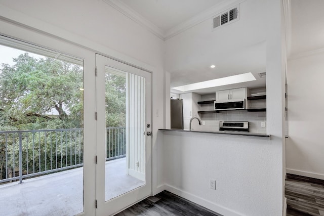 entryway featuring dark wood-style flooring, a sink, visible vents, baseboards, and crown molding