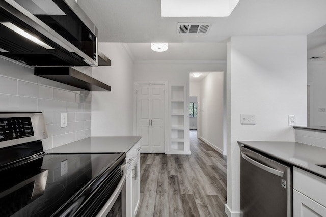 3840 Far W Blvd Unit 215, Austin, TX 78731 - kitchen with stainless steel appliances, white cabinets, light wood-type flooring, backsplash, and crown molding