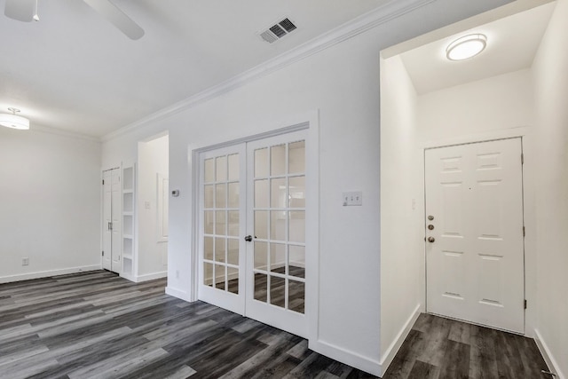 foyer entrance with baseboards, visible vents, dark wood-type flooring, and ornamental molding