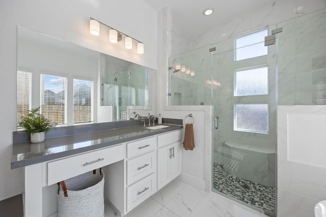 full bathroom featuring marble finish floor, plenty of natural light, a marble finish shower, and vanity