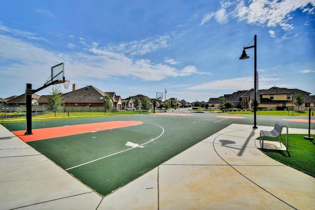 view of basketball court featuring community basketball court, a residential view, and fence