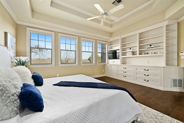 bedroom featuring dark wood-type flooring, a raised ceiling, visible vents, and ornamental molding