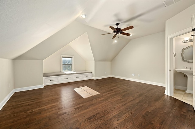 bonus room with lofted ceiling, baseboards, visible vents, and dark wood-type flooring