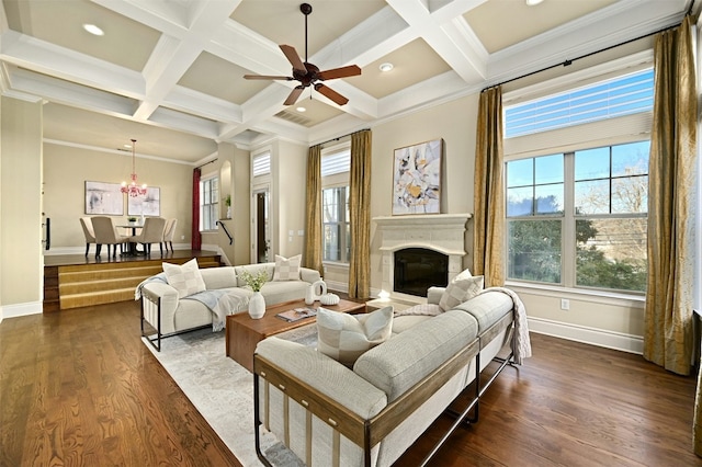 living area with dark wood-style floors, a glass covered fireplace, coffered ceiling, and beamed ceiling