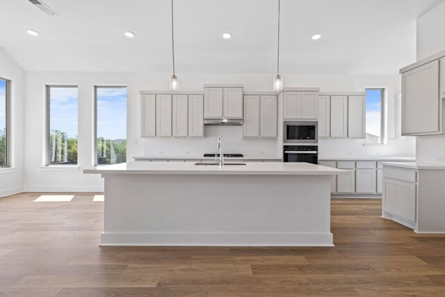 100 Wild Bluebell Cv, Georgetown, TX 78628 - kitchen featuring oven, stainless steel microwave, light countertops, decorative backsplash, and recessed lighting