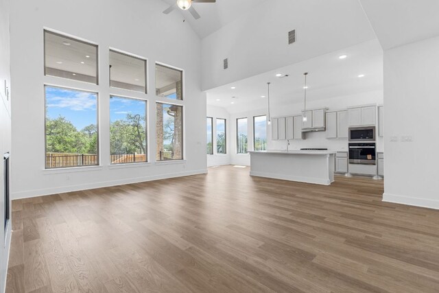 100 Wild Bluebell Cv, Georgetown, TX 78628 - unfurnished living room with ceiling fan, high vaulted ceiling, light wood-style flooring, and recessed lighting