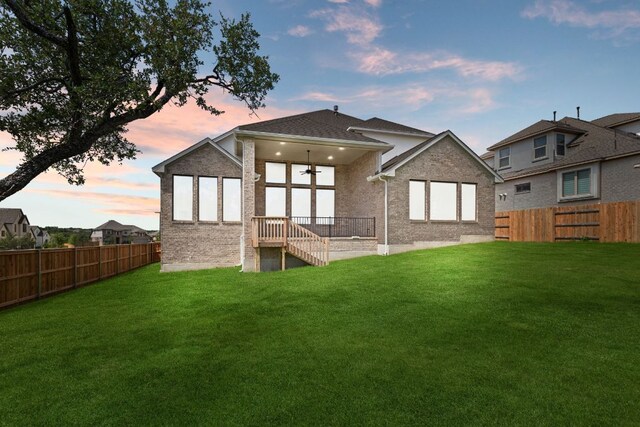 100 Wild Bluebell Cv, Georgetown, TX 78628 - back of property at dusk featuring a fenced backyard and brick siding