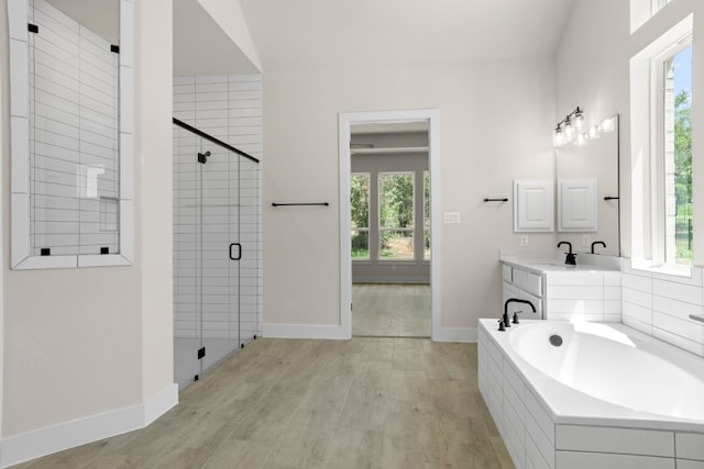 full bath featuring a garden tub, plenty of natural light, a shower stall, and wood finished floors