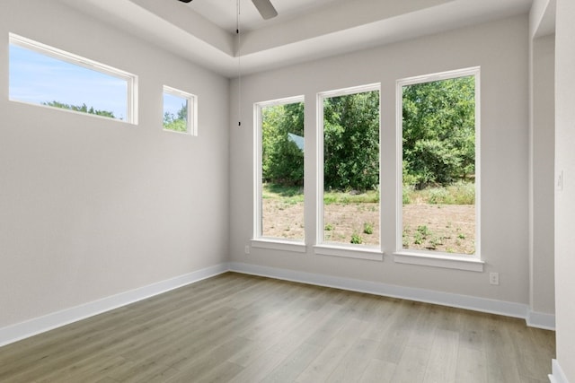 empty room with ceiling fan, baseboards, and wood finished floors