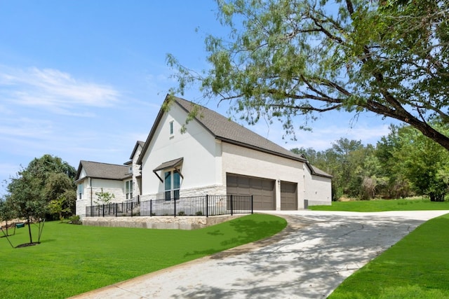 exterior space featuring an attached garage, stucco siding, driveway, and a yard