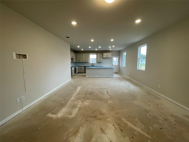 kitchen with open floor plan, recessed lighting, a sink, and baseboards