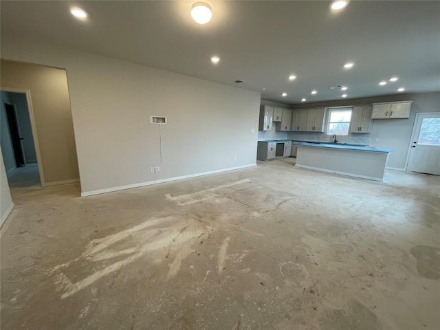 unfurnished living room featuring recessed lighting, baseboards, and unfinished concrete floors