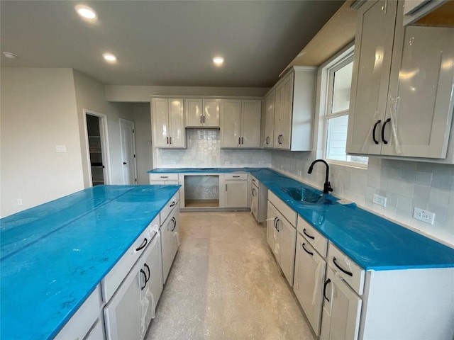 kitchen with dark countertops, recessed lighting, a sink, and gray cabinetry