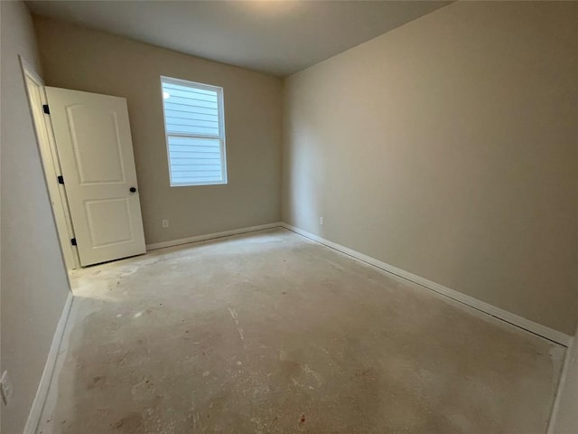 empty room with baseboards and unfinished concrete floors