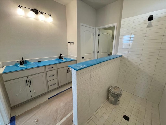 full bathroom with tile patterned flooring, a sink, and double vanity