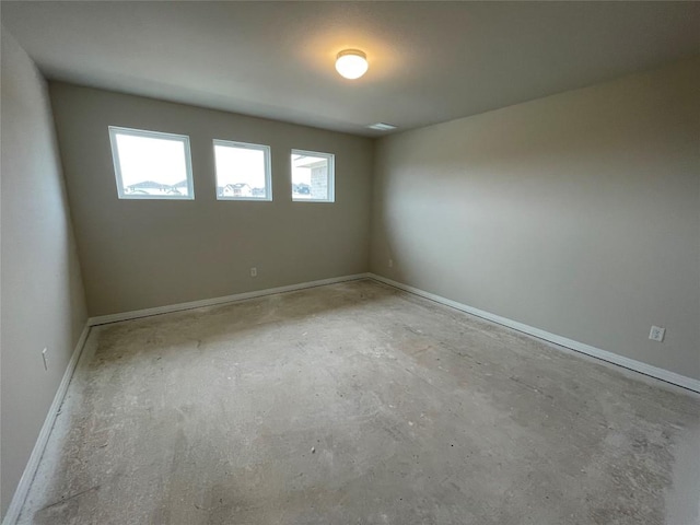 spare room with concrete floors and baseboards