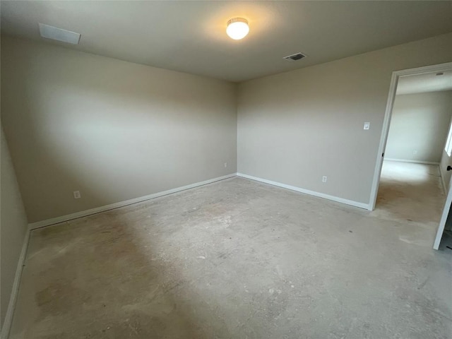 spare room with visible vents, unfinished concrete flooring, and baseboards