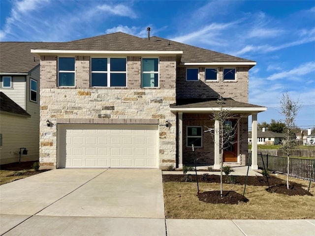 view of front of property featuring concrete driveway, stone siding, an attached garage, fence, and brick siding