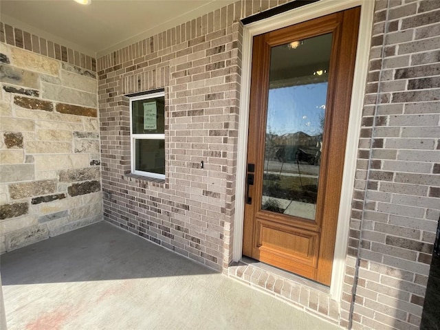 doorway to property with brick siding