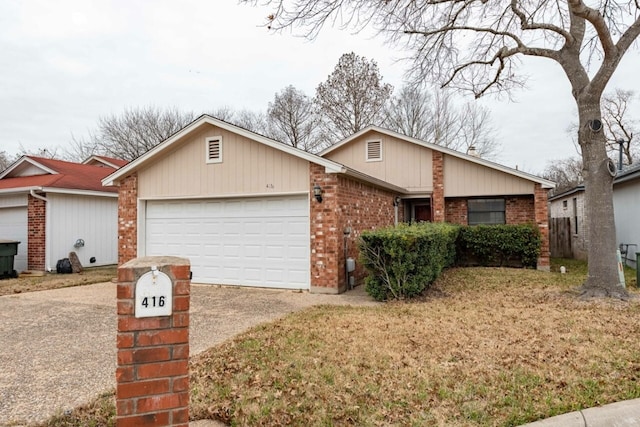 view of front of house with an attached garage, a front lawn, concrete driveway, and brick siding