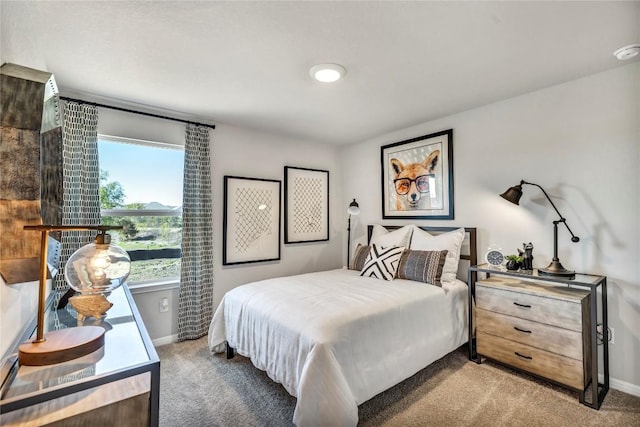 bedroom featuring light carpet and baseboards