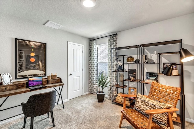 carpeted home office featuring a textured ceiling, visible vents, and baseboards