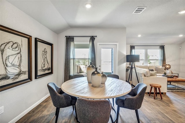 dining space featuring baseboards, visible vents, lofted ceiling, dark wood-style flooring, and recessed lighting