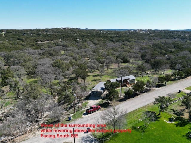 birds eye view of property with a wooded view