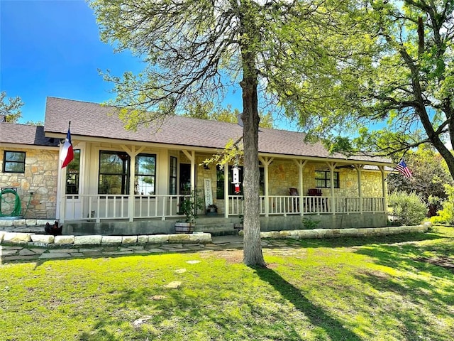 view of front of property featuring stone siding, a front lawn, and a porch