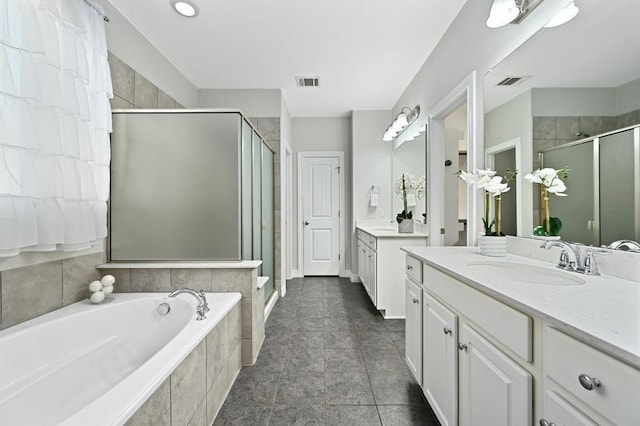 bathroom with a stall shower, visible vents, a garden tub, and a sink