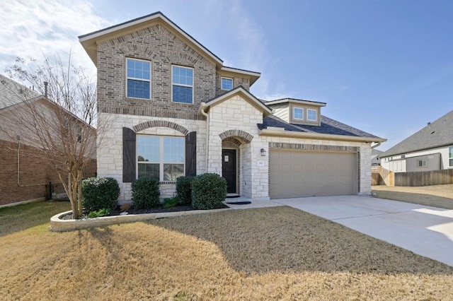 view of front of home featuring driveway, brick siding, stone siding, an attached garage, and a front yard