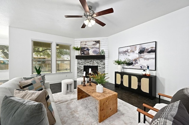 living area featuring plenty of natural light, a stone fireplace, baseboards, and ceiling fan