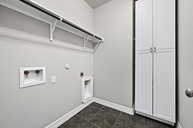 laundry room featuring hookup for a washing machine, cabinet space, hookup for an electric dryer, dark tile patterned flooring, and baseboards