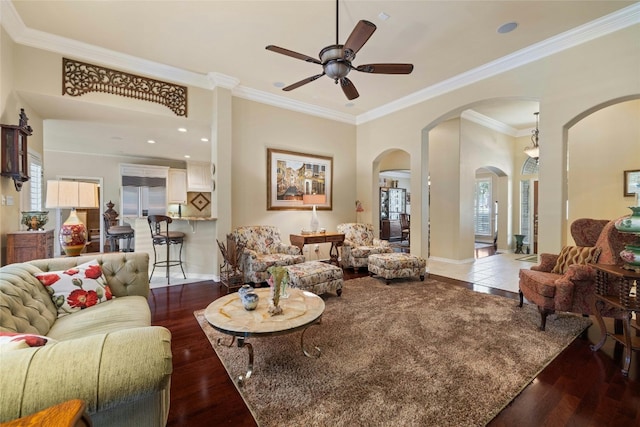 living room featuring dark wood-style floors, ornamental molding, and baseboards