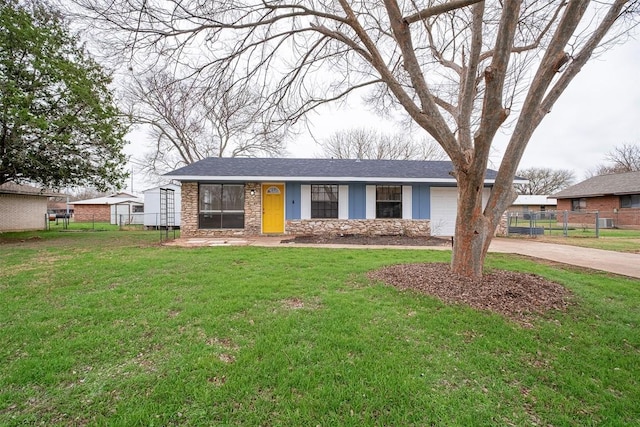 ranch-style home with a garage, fence, stone siding, concrete driveway, and a front lawn